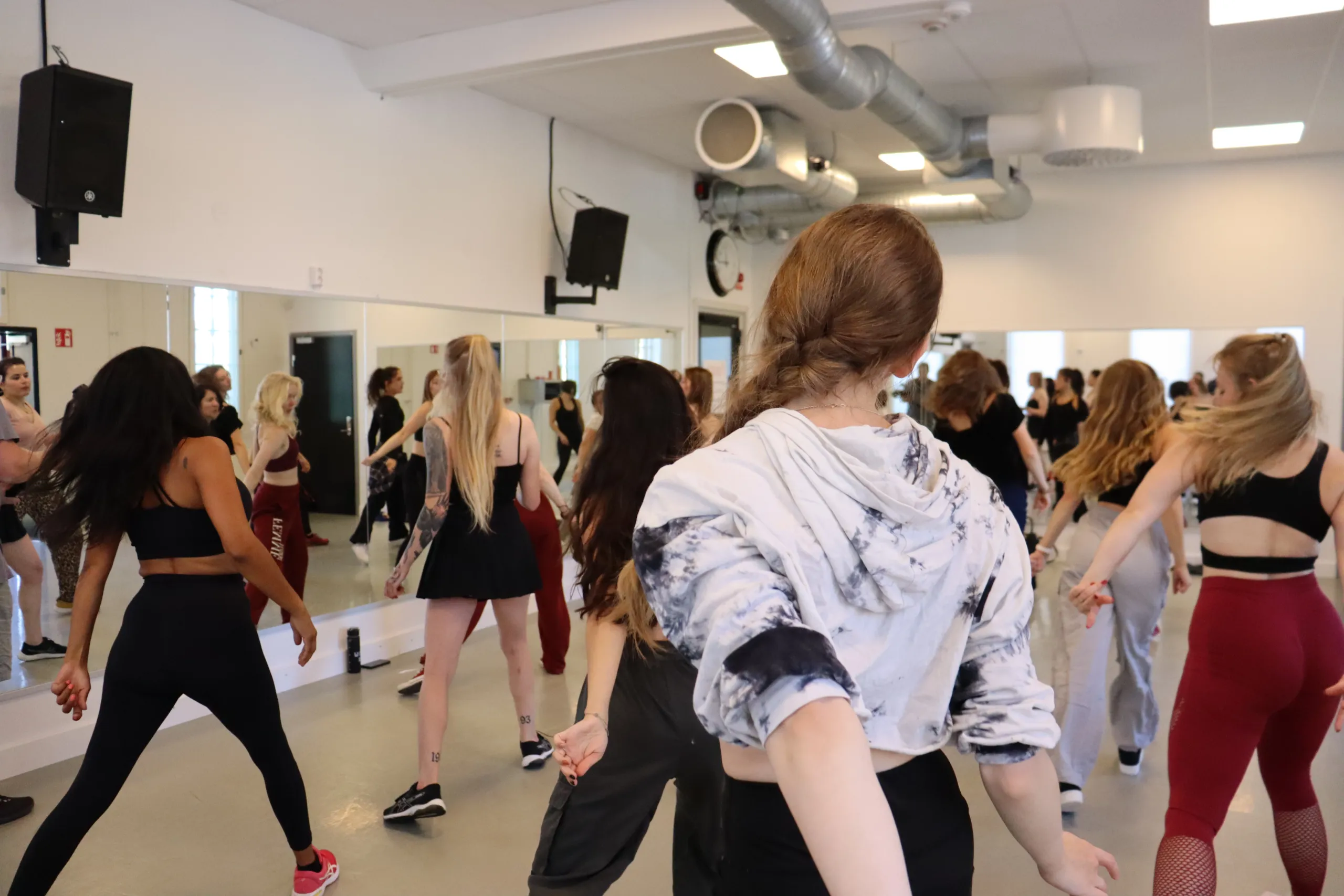 Deltagare på dansklass utför koreografi i grupp i ljus dansstudio.