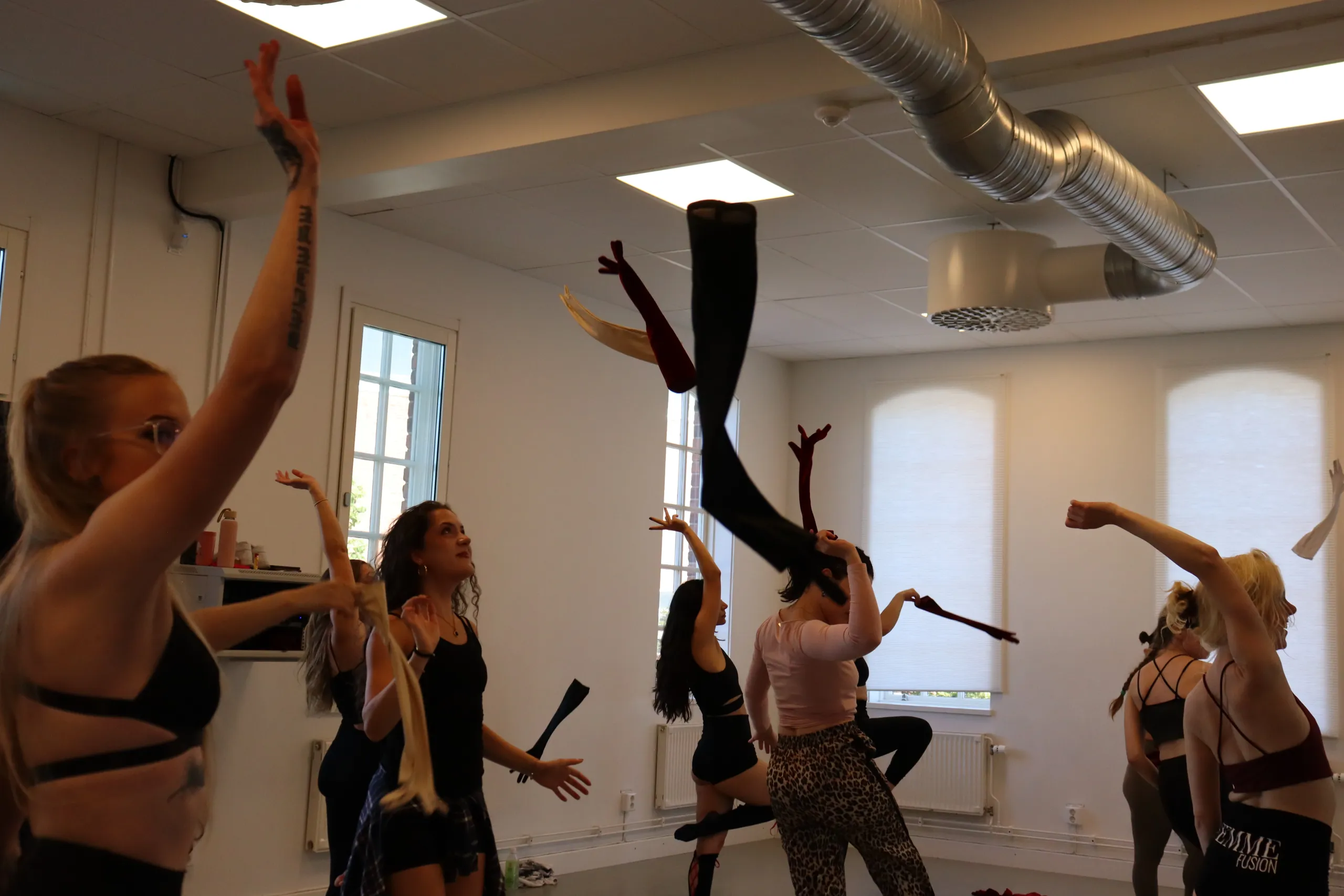 Deltagare på dansklass tränar koreografi i inspirerande och trygg miljö.